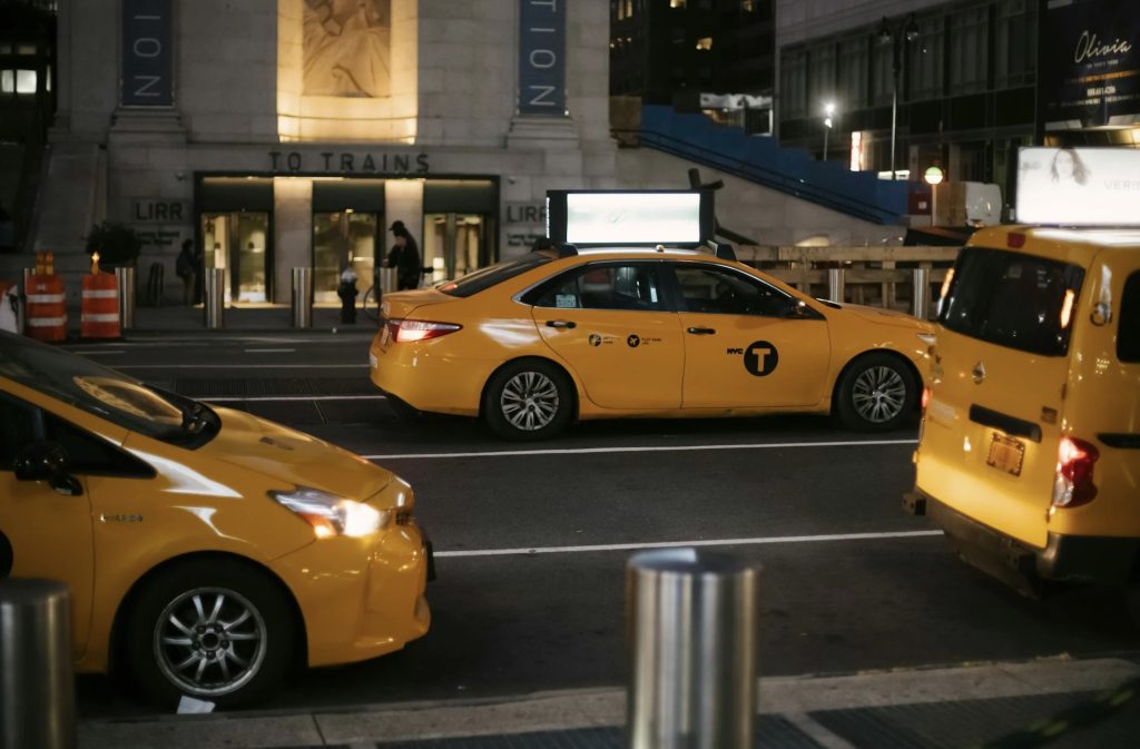 Three taxis on street at night in NYC